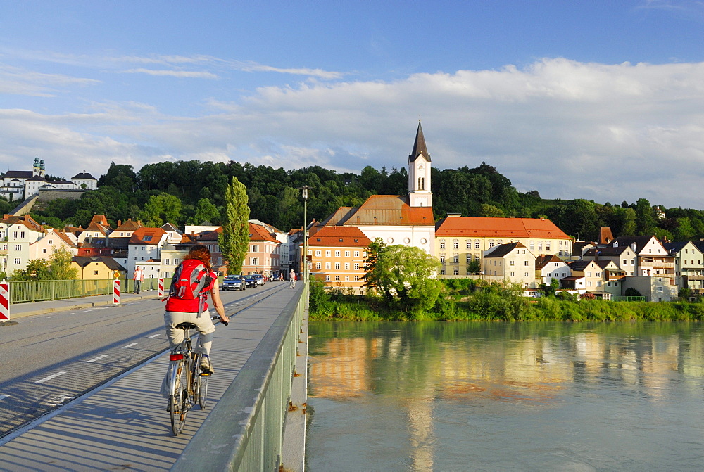 Female cyclist passing bridge over river Inn, Danube Cycle Route Passau Vienna, Passau, Lower Bavaria, Bavaria, Germany