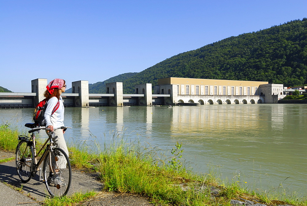 Female cyclist near river Danube, Run-of-the-river hydroelectricity Jochenstein, Danube Cycle Route Passau to Vienna, Upper Austria, Austria