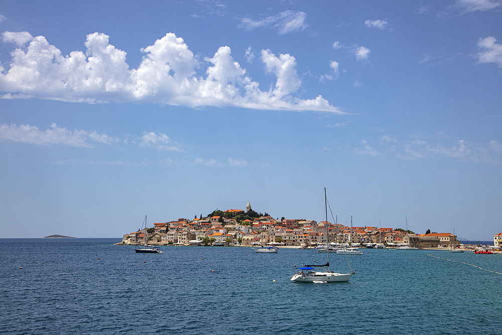 Sailboats moored in the harbor with the old town in the distance, Primosten, Šibenik-Knin, Croatia, Europe