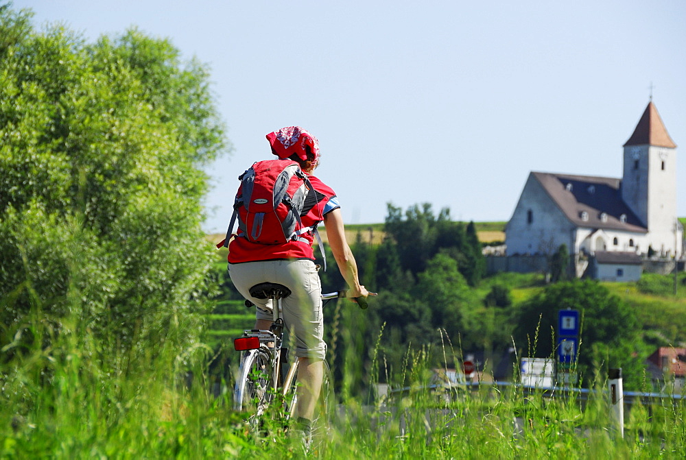 Female cyclist, St. Nicholas' Church, Danube Cycle Route Passau Vienna, Lower Austria, Austria