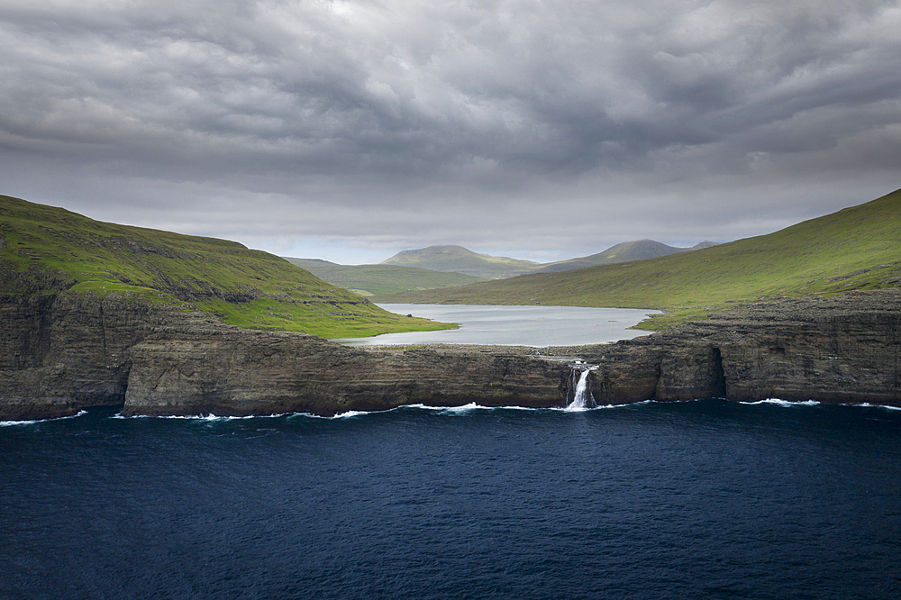 Coast, waterfall and cliffs at Trælanípa on the island of Vagar, on Lake Leitisvatn, Faroe Islands