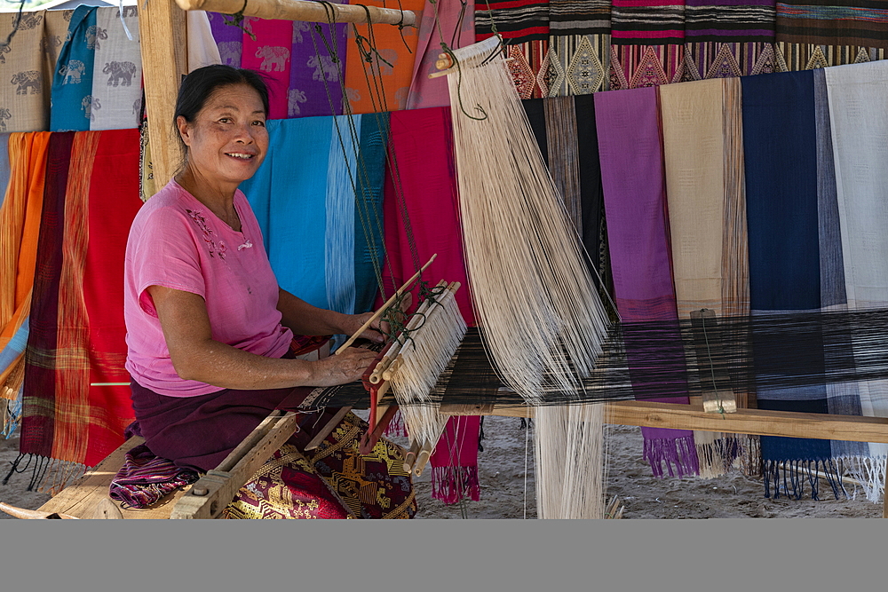 Woman weaves silk scarves on a loom in a local market, Pak Ou, Luang Prabang Province, Laos, Asia