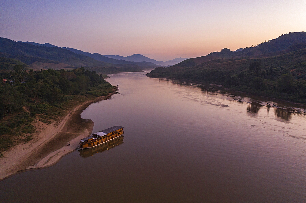 Aerial view of river cruise ship Mekong Sun moored on the sandy bank of the Mekong River at dusk, Ban Hoy Palam, Pak Tha District, Bokeo Province, Laos, Asia