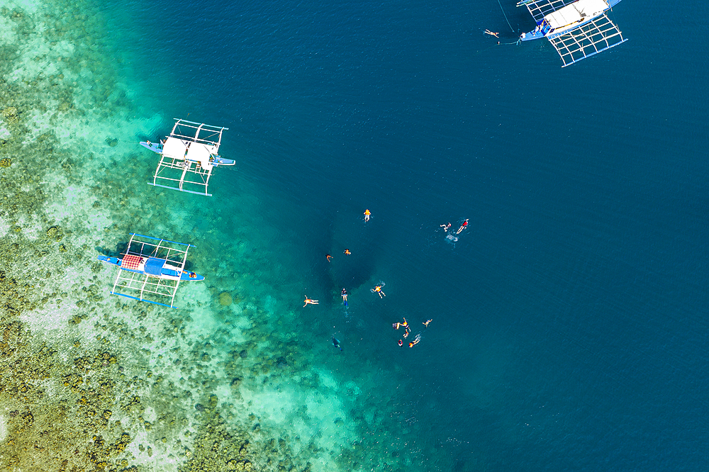 Aerial view of guests enjoying a snorkeling trip at the Skeleton Wreck shipwreck off Coron Island, Banuang Daan, Coron, Palawan, Philippines, Asia