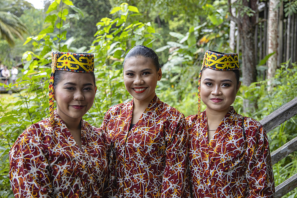 Three friendly women in traditional costume in the Sarawak Cultural Village, Kampung Budaya Sarawak, near Kuching, Sarawak, Borneo, Malaysia, Asia