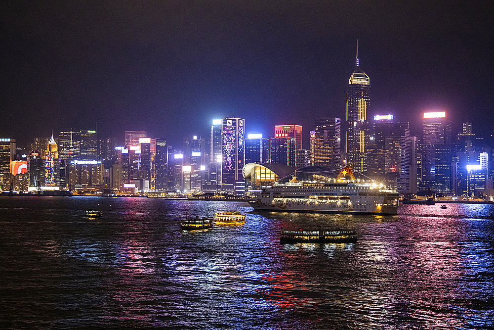 Cruise ship Pisces in Victoria Harbor with city skyline at night, Hong Kong, Hong Kong, China, Asia