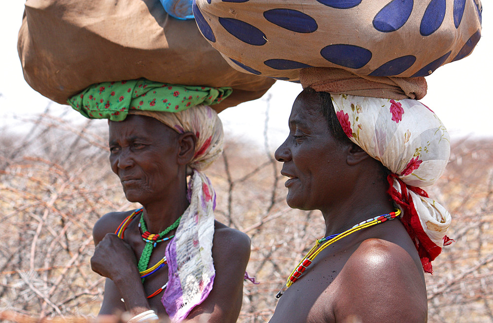 Angola; western part of the province of Cunene; two women by the roadside; carrying her luggage on her head