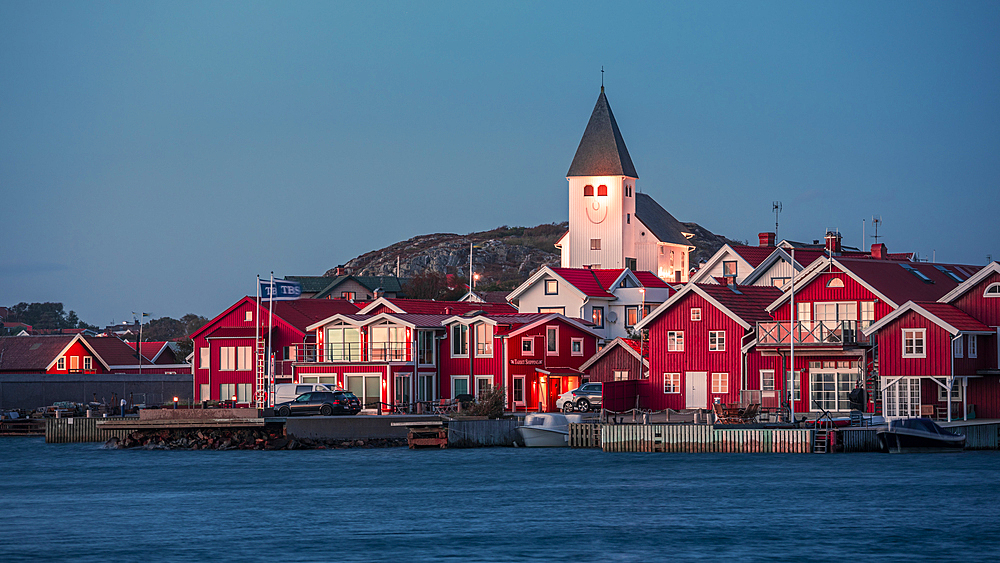 Red houses with a church in the village of Skärhamn on the archipelago island of Tjörn on the west coast of Sweden, in the evening