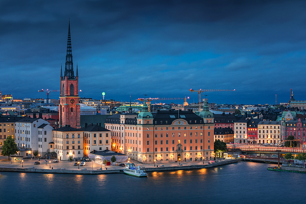 Illuminated skyline of Stockholm at night with Riddarholmskyrkan church on Gamla Stan old town island in Sweden