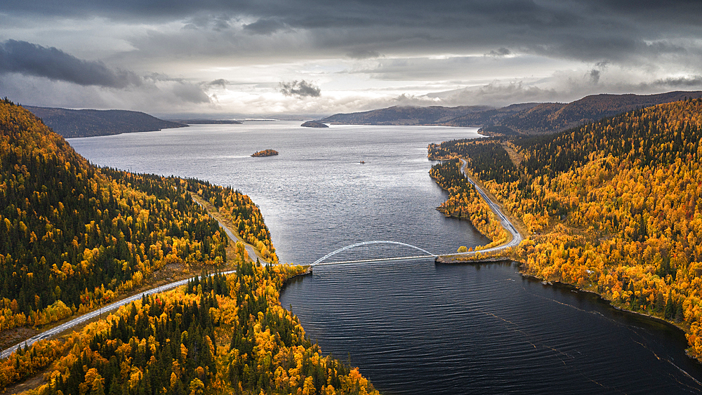 Panoramic road Wilderness Road with bridge over river and trees in autumn in Lapland in Sweden from above