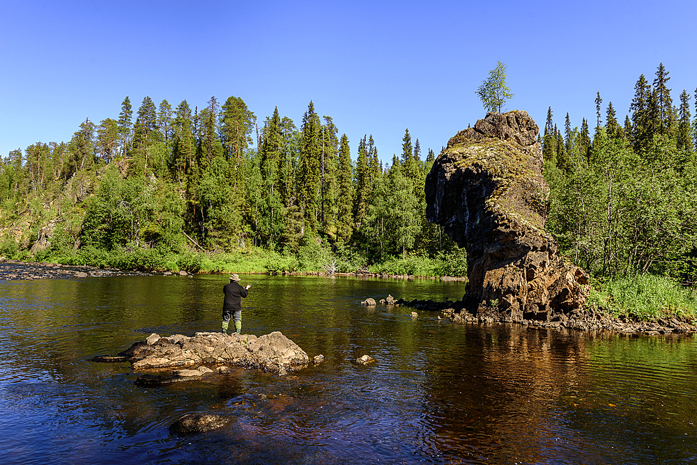 At the Rupkivi characteristic rock in the Savinajoki river, anglers on the Bear Circle hiking trail, Finland