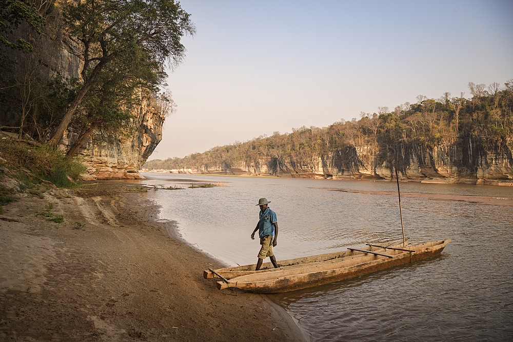 Man getting out of boat on Manambolo River, Tsingy de Bemaraha National Park, Bekopaka, Madagascar, Mahajanga Province, Africa, UNESCO World Heritage Site