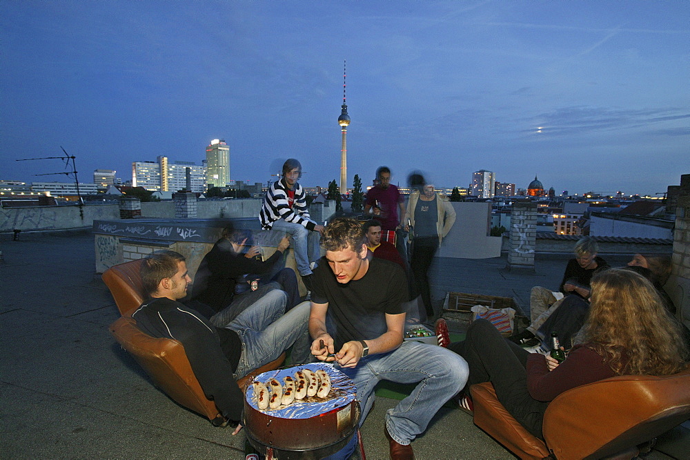 Rooftop party, young people, Prenzlauer Berg with view of night skyline, TV tower, Berlin, Germany