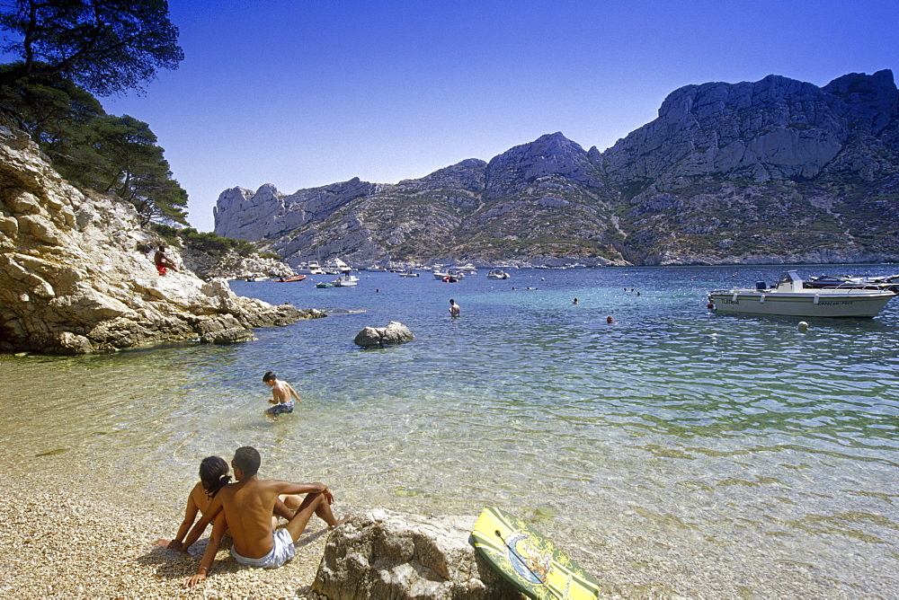 Young couple on the beach under blue sky, Calanque de Sormiou, Cote d'Azur, Provence, France, Europe