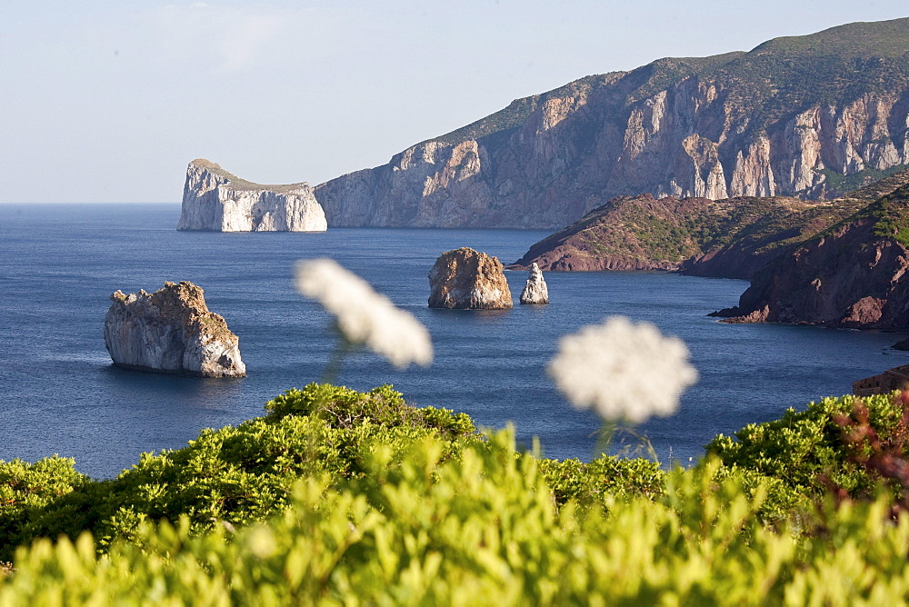 Pan di Zucchero, rocks off shore in the sunlight, Masua, Sardinia, Italy, Europe