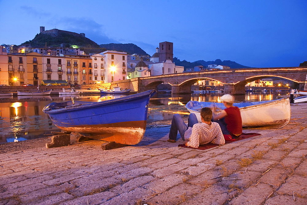 Two at the banks of the river Fiume Temo at dusk, view to the Castello di Serravalle, Bosa, Sardinia, Italy, Europe