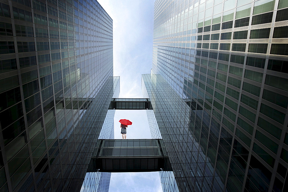 Woman with red umbrella between high-rise buildings, Munich, Bavaria, Germany (digital composite)