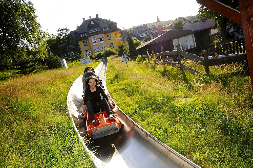 Tourists on the summer toboggan run in Karpacz, Bohemian mountains, Lower-Silesia, Poland, Europe