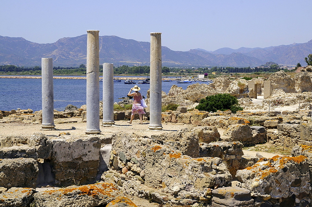 A woman at the excavations of the antique town Nora, South Sardinia, Italy, Europe