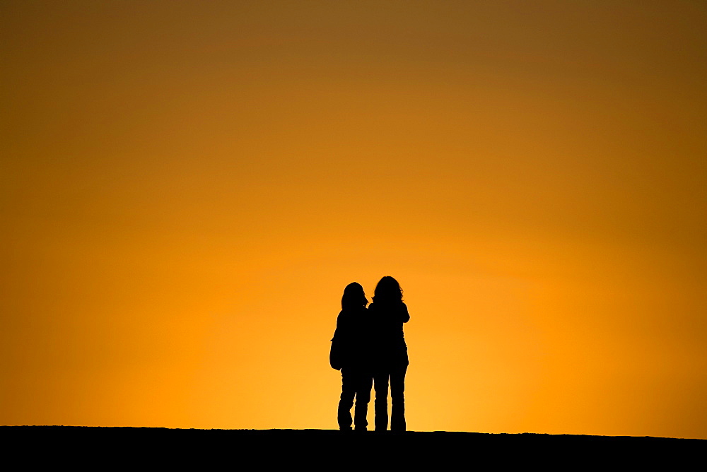 Two women watching the sunset, Puerto de Tazacorte, UNESCO Biosphere Reserve, La Palma, Canary Islands, Spain, Europe