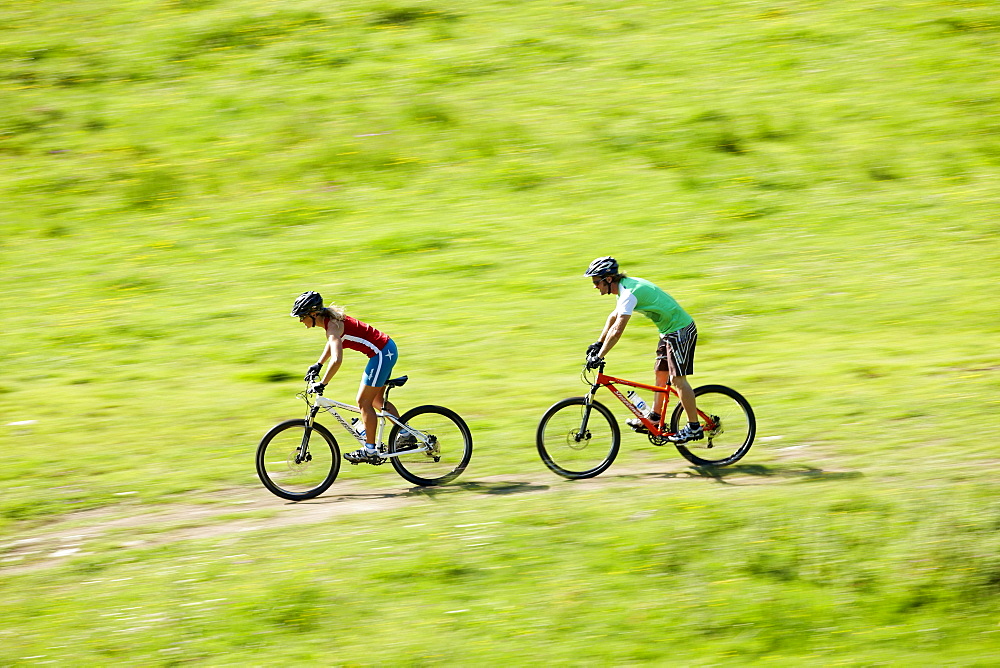 Man and woman riding mountain bikes, Spitzingsee, Bavaria, Germany