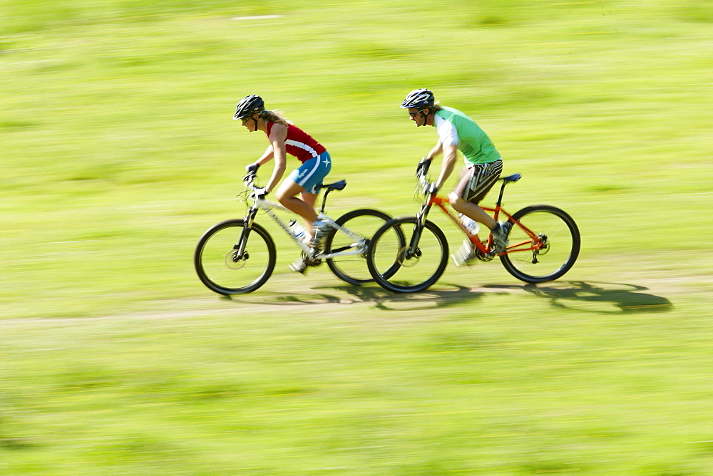 Man and woman riding mountain bikes, Spitzingsee, Bavaria, Germany