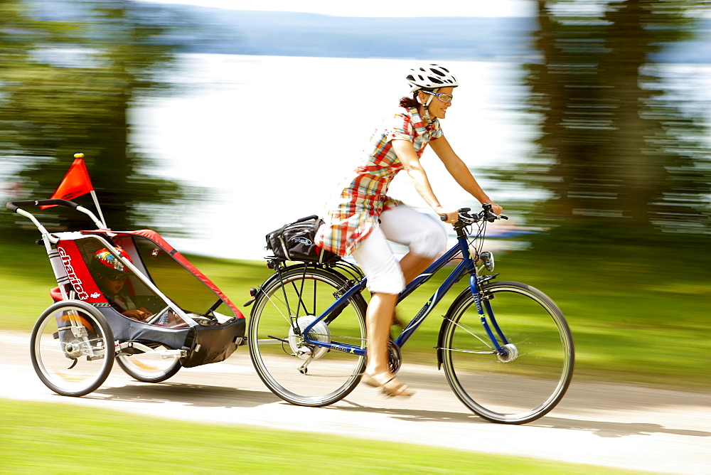 Cyclist with child trailer, Lake Starnberg, Bavaria, Germany