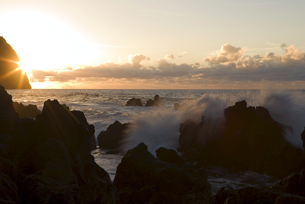 Breaker wave crashing on lava rocks at sunset, Porto Moniz, Madeira, Portugal