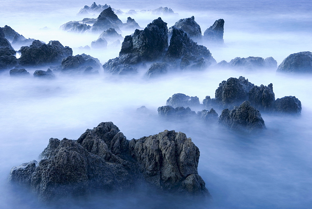 Lava rocks at dusk surrounded by sea water, Porto Moniz, Madeira, Portugal