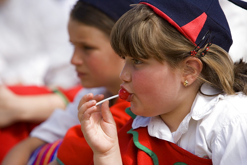 Girl enjoying a lollipop during the Childrens Parade at the Madeira Flower Festival, Funchal, Madeira, Portugal