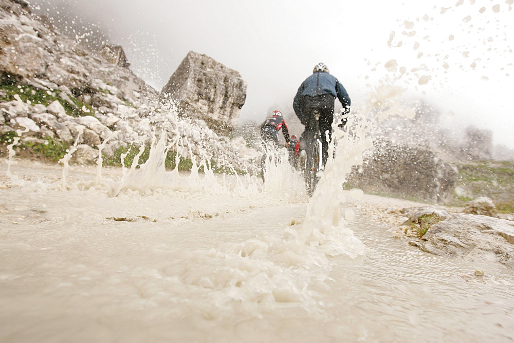 Persons mountain biking near Tre Cime di Lavaredo, Veneto, Italy
