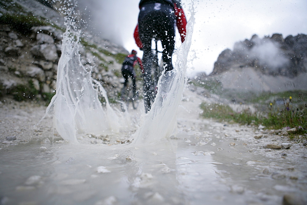Persons mountain biking near Tre Cime di Lavaredo, Veneto, Italy