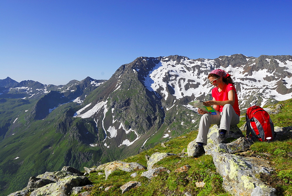 Female hiker reading map, Stubai Alps, Trentino-Alto Adige/South Tyrol, Italy