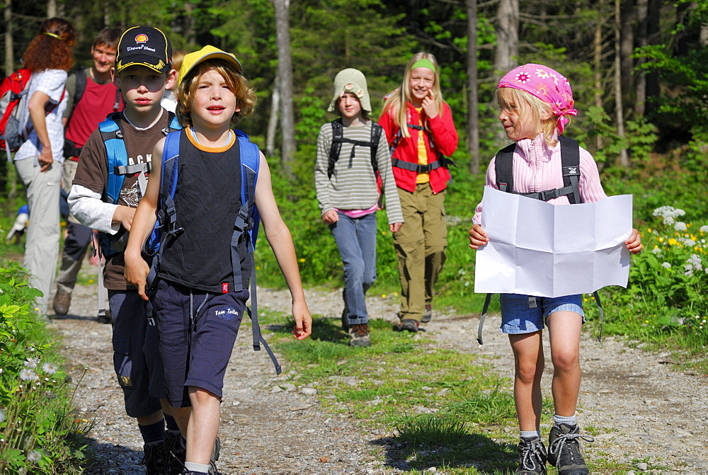 Group of hikers with children, girl reading a map, Bavarian Alps, Upper Bavaria, Bavaria, Germany