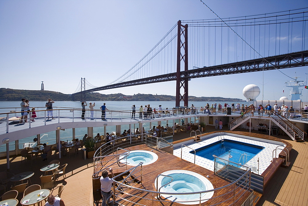 Pool deck of cruiseship MS Delphin Voyager as vessel approaches Ponte 25 de Abril Bridge on Tagus River, Lisbon, Lisboa, Portugal