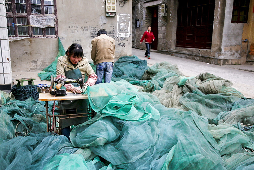 Female tailor working on fishing nets on the street, Jinfeng, Changle, Fujian province, China, Asia