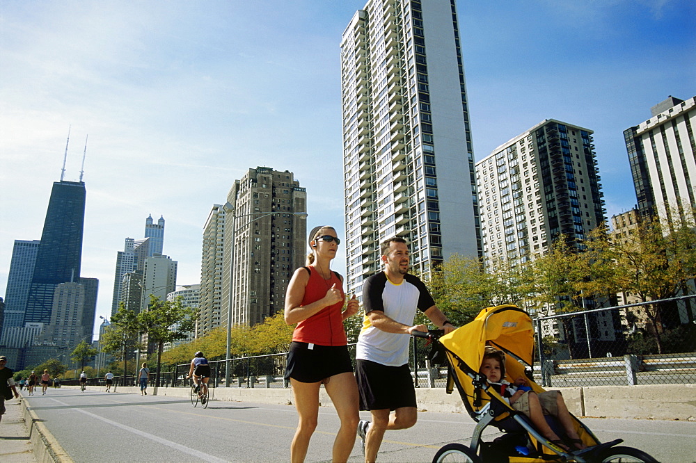 Young family jogging atOak Street Beach, Gold Coast, Chicago, Illinois, USA