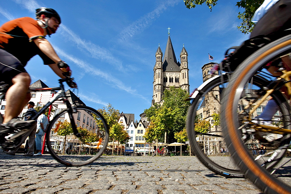 Cyclists near church Great St. Martin, Old town, Cologne, North Rhine-Westphalia, Germany