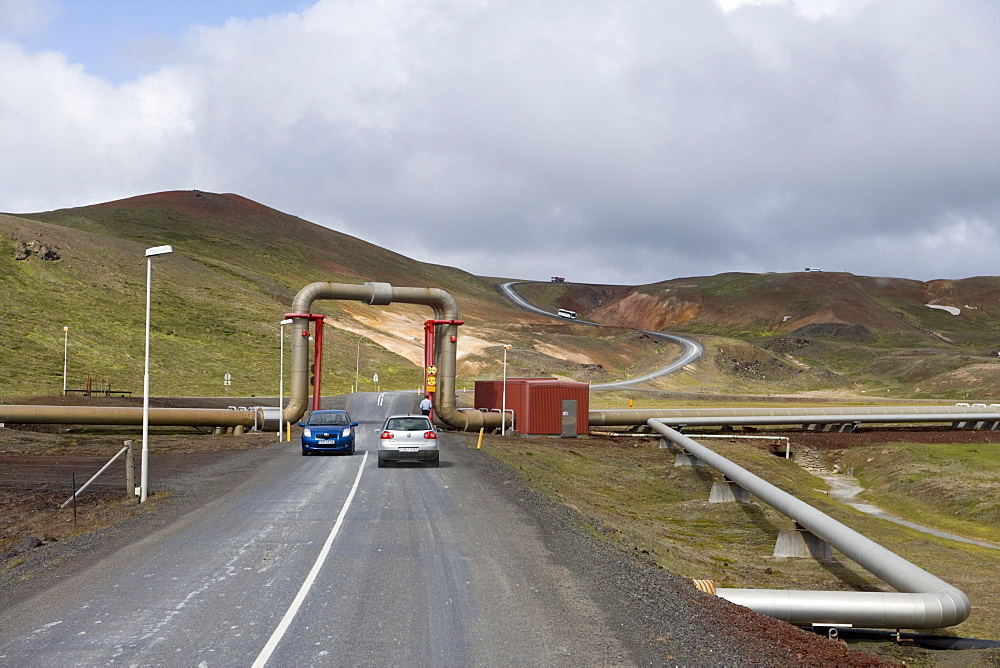 Hot water pipes above a street at Krafla Geothermal Area, Krafla, Nordurland Eystra, Iceland, Europe