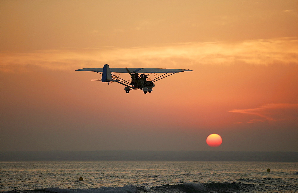 Ultralight plane flying over the beach of Es Trenc, Mallorca, Balearic Islands, Spain