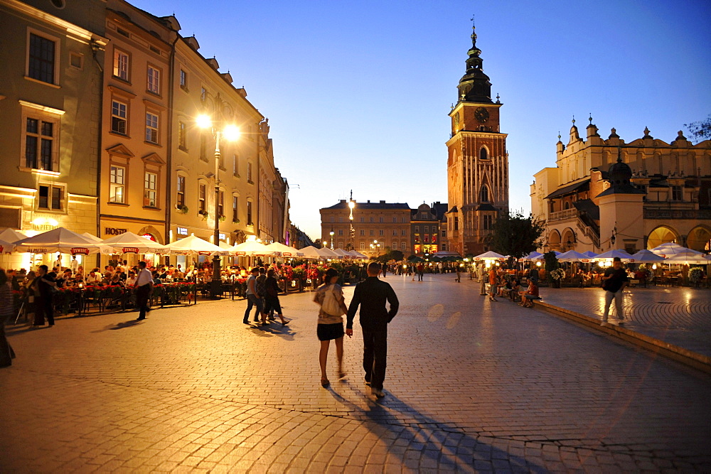 Rynek glowny, market place with street cafes and town hall tower at dusk, Krakow, Poland, Europe