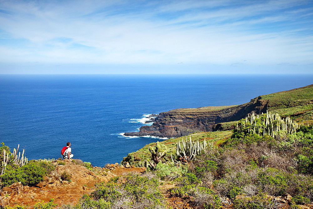Hiker at the coast looking at the sea, Santo Domingo de Garafia, La Palma, Canary Islands, Spain, Europe