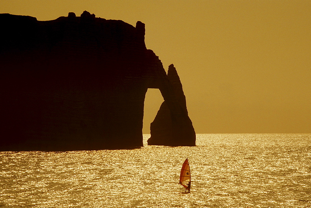 Sail boarder at the rock formation Falaise dÂ¥Aval in the evening light, Normandy, France, Europe