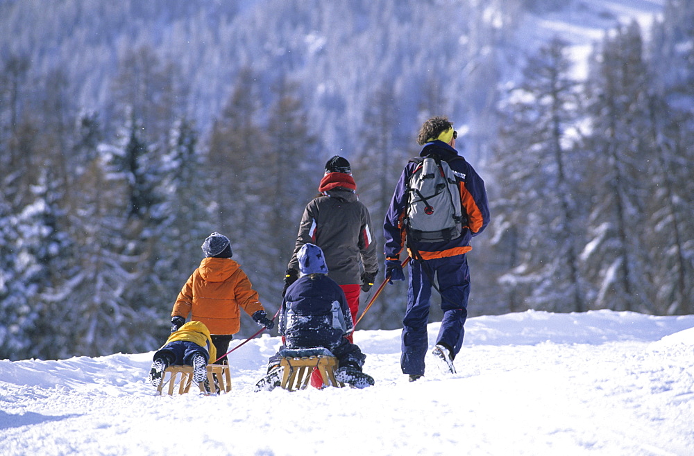 Family taking a walk in the ski resort of Motta Naluns above Scuol, Lower Engadine, Engadine, Switzerland