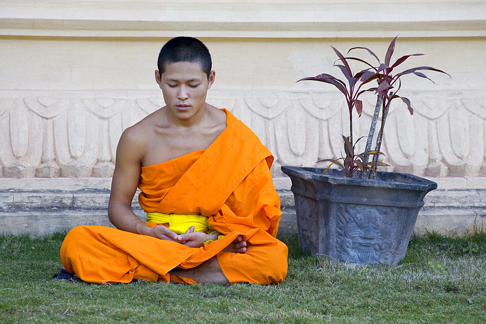 Buddhistic monk sitting in front of monastery Vat Pa Phonphao, Luang Prabang, Laos