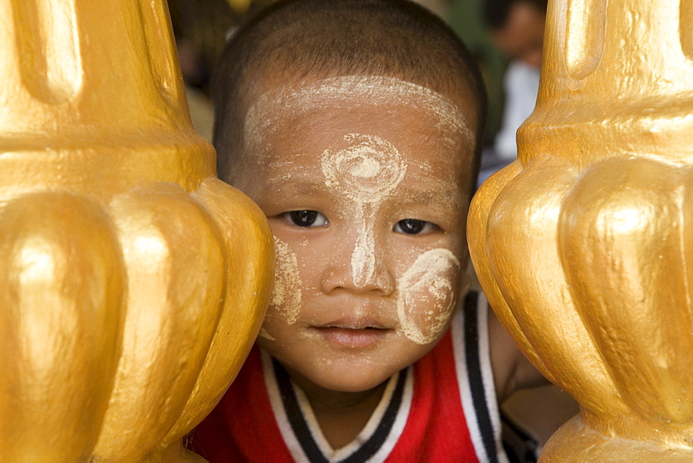 Face of a young burmese boy on the grounds of the Shwedagon Pagoda at Yangon, Rangoon, Myanmar, Burma