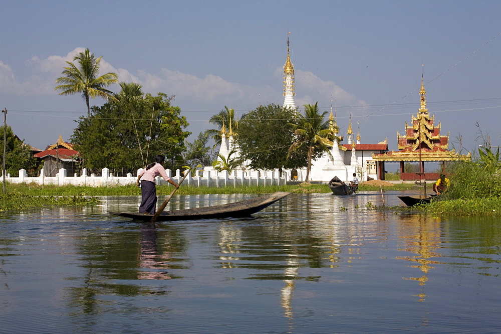 Young woman in a canoe in front of pagodes at Inle Lake, Myanmar, Shan State, Burma