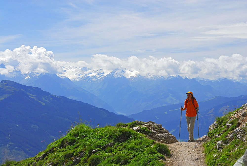 young woman on trail above valley of Maria Alm with view to Hohe Tauern range, Steinernes Meer range, Berchtesgaden range, Salzburg, Austria