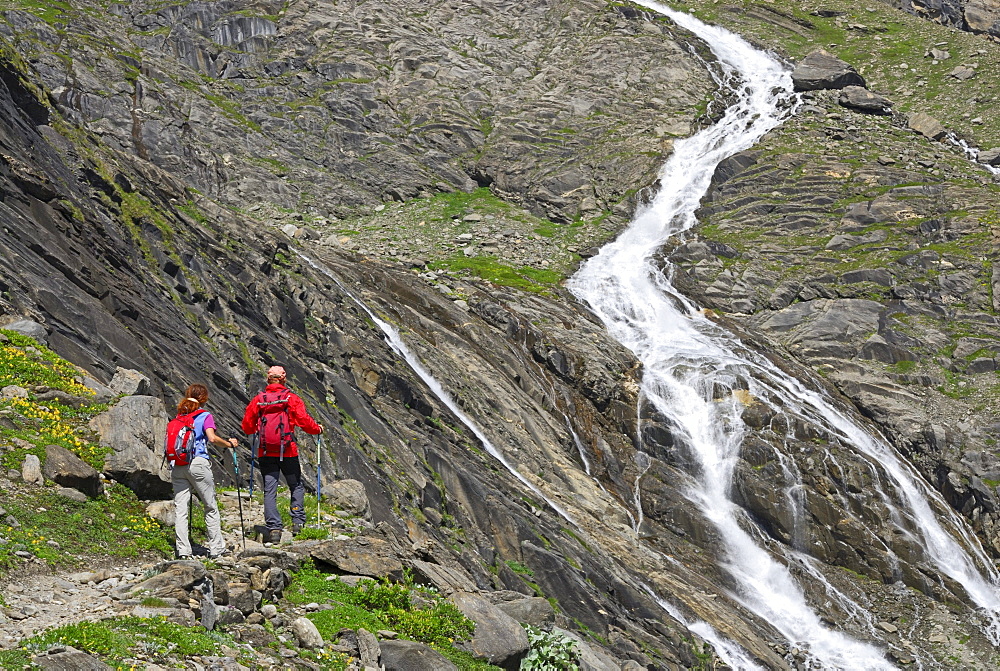 young couple on trail with view to stream, ascent to hut Schwarzenberghuette, Hohe Tauern range, National Park Hohe Tauern, Salzburg, Austria