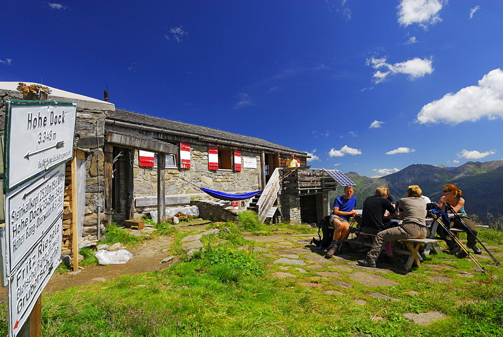 hikers in front of hut Schwarzenberghuette, Hohe Tauern range, National Park Hohe Tauern, Salzburg, Austria